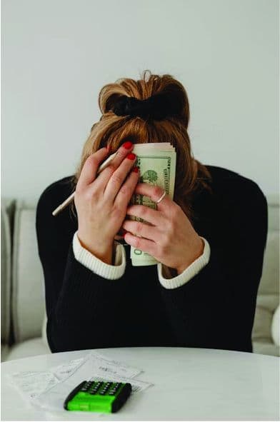 Person stressed over bills and a calculator
