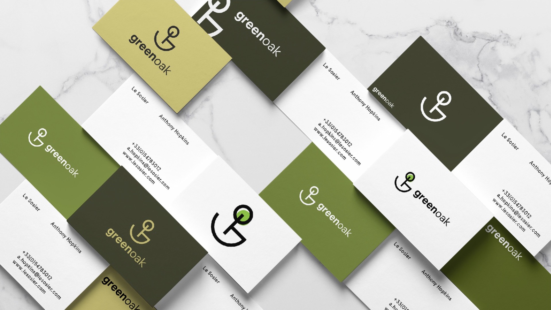 Business cards in straw, olive and white scattered on marble