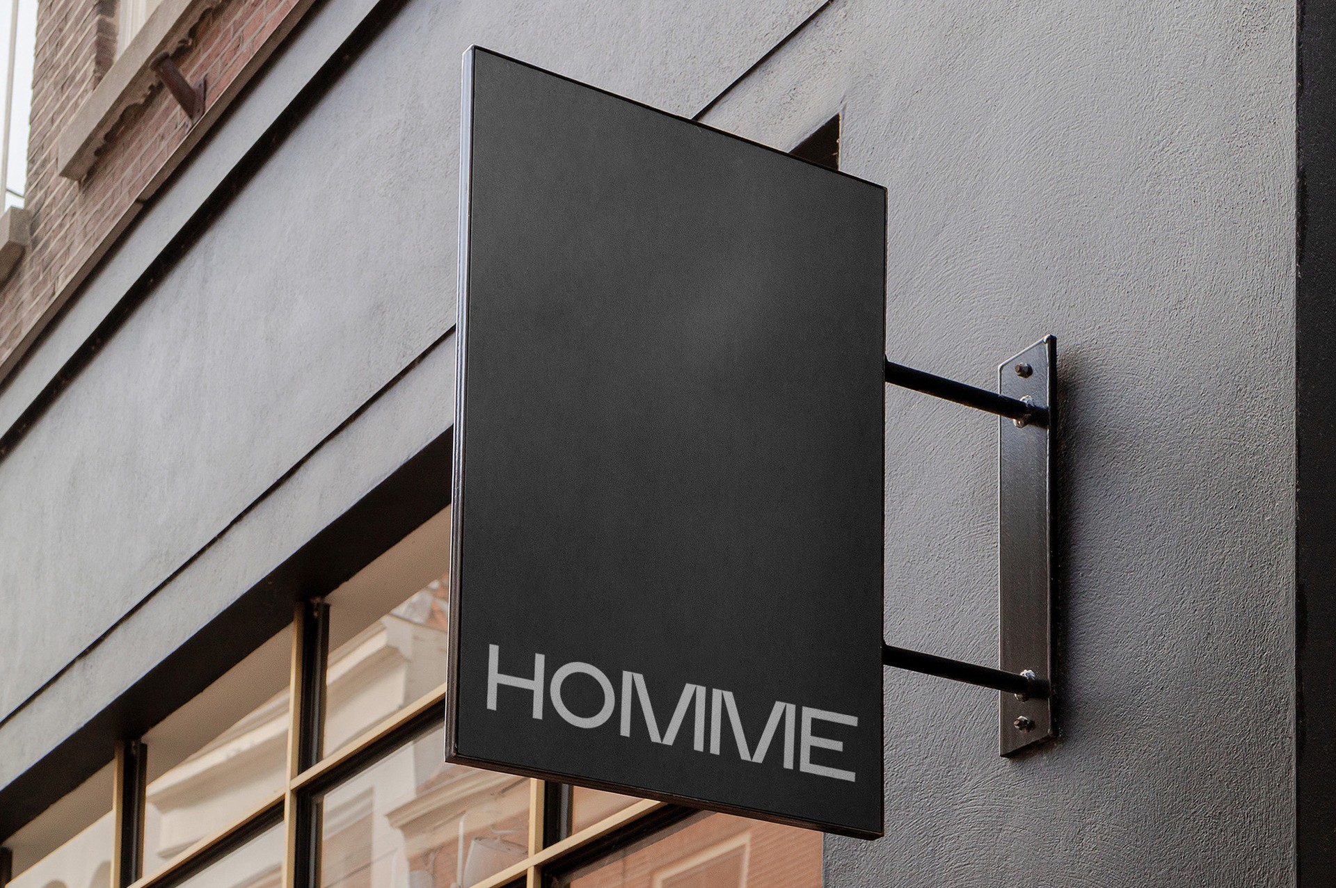 Black projecting sign with the wordmark on a grey building