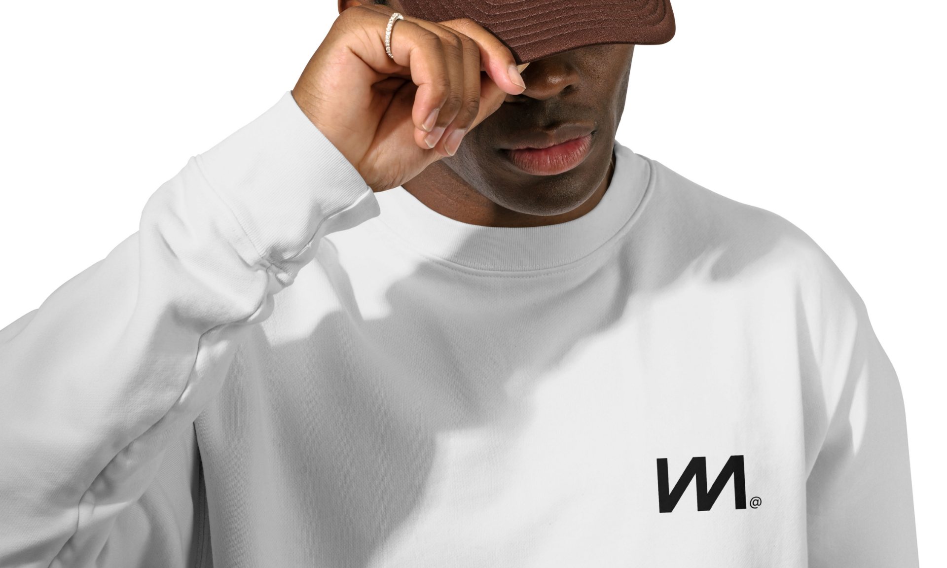 A man in a white sweatshirt with a small M on the chest