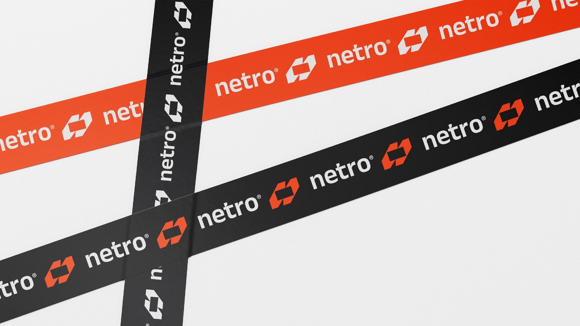 Crossing strips of orange and black tape printed with the logo