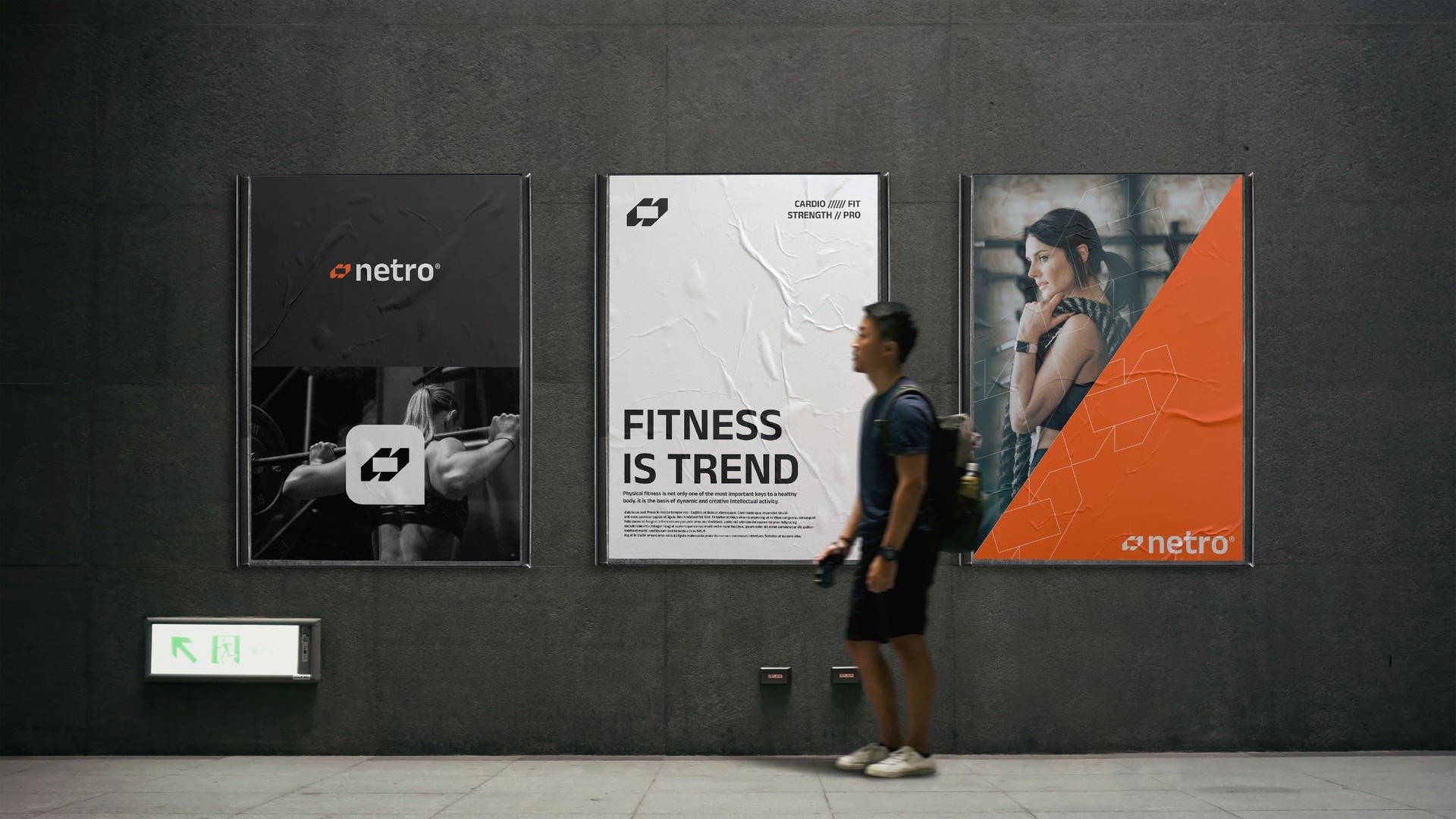 A man walking past three Netro posters in a subway