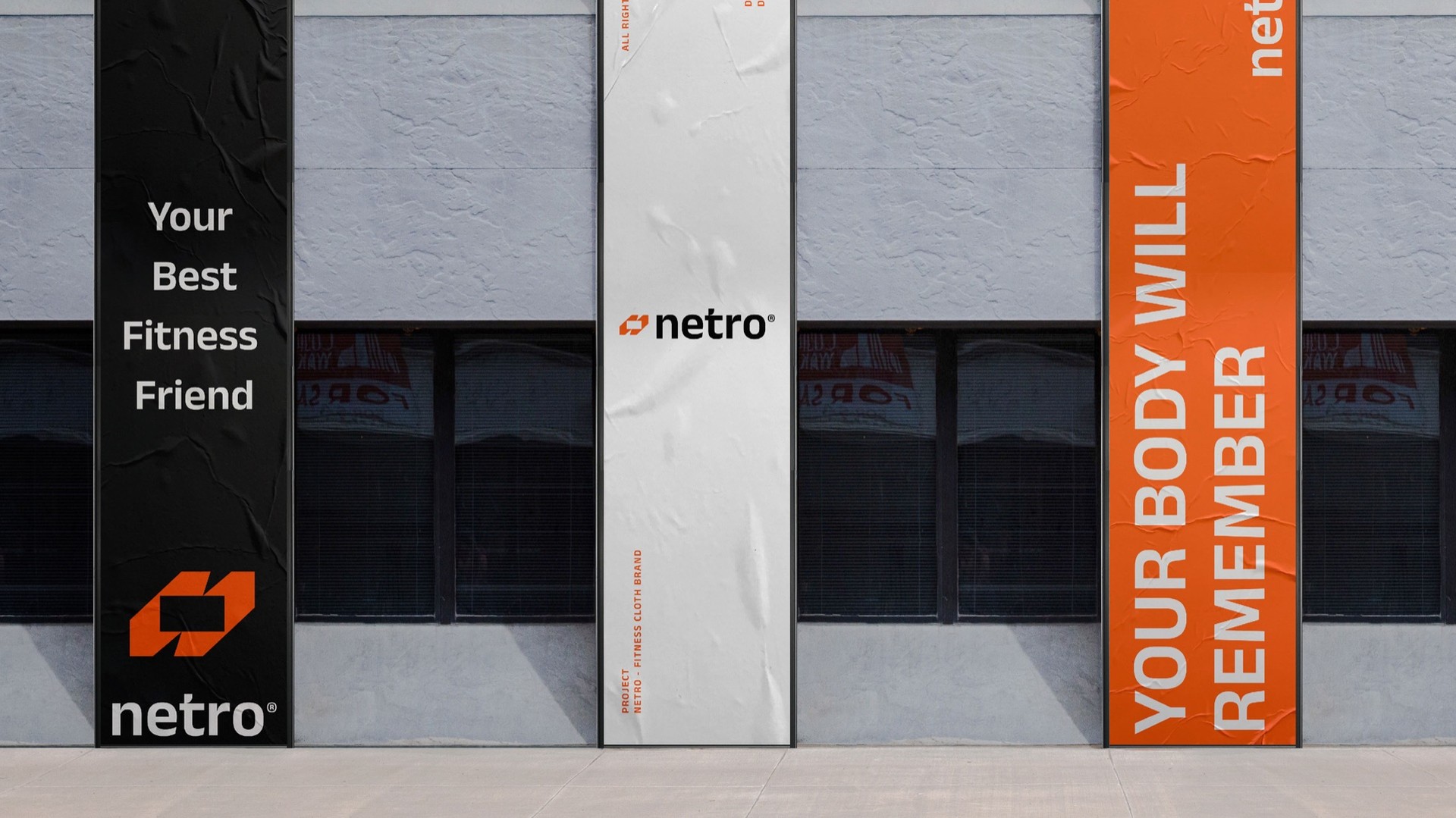 Tall street banners in black, white and orange along a wall