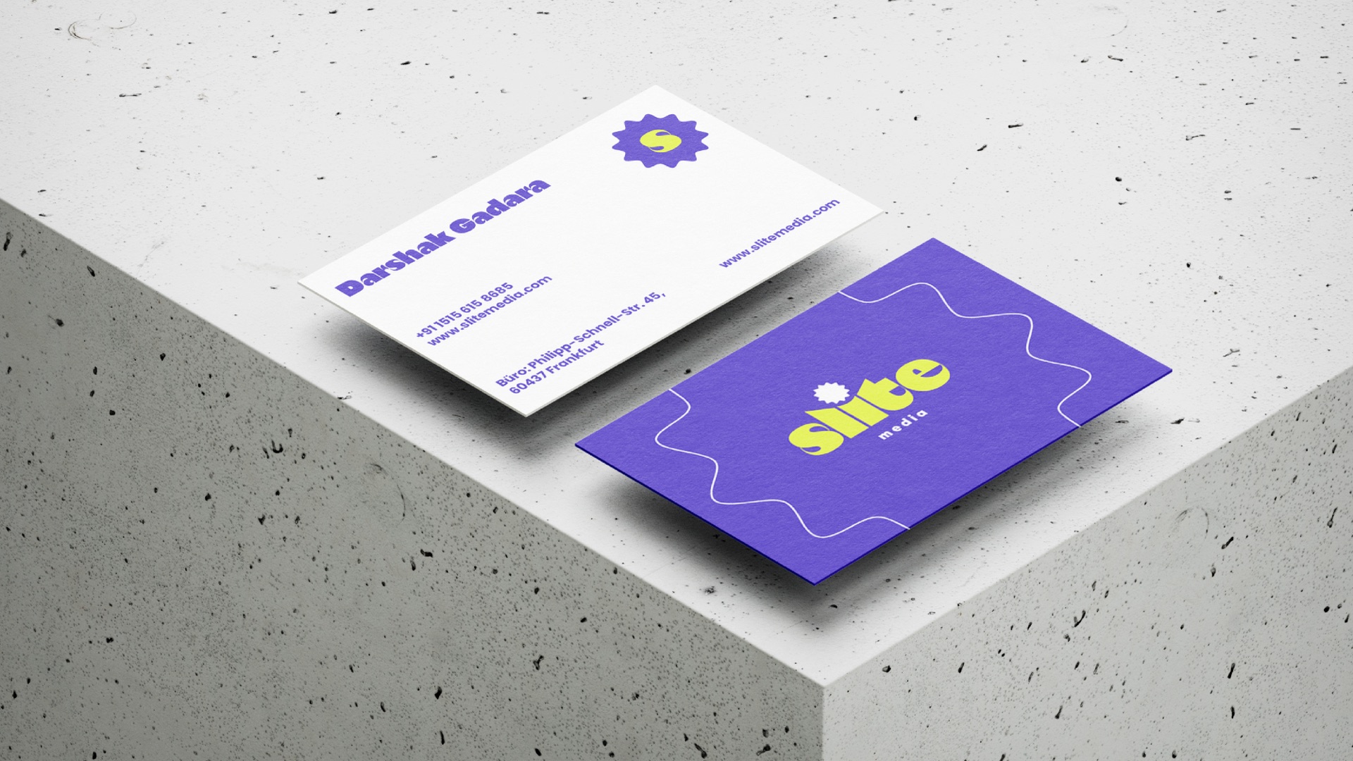 White and purple business cards on a concrete block