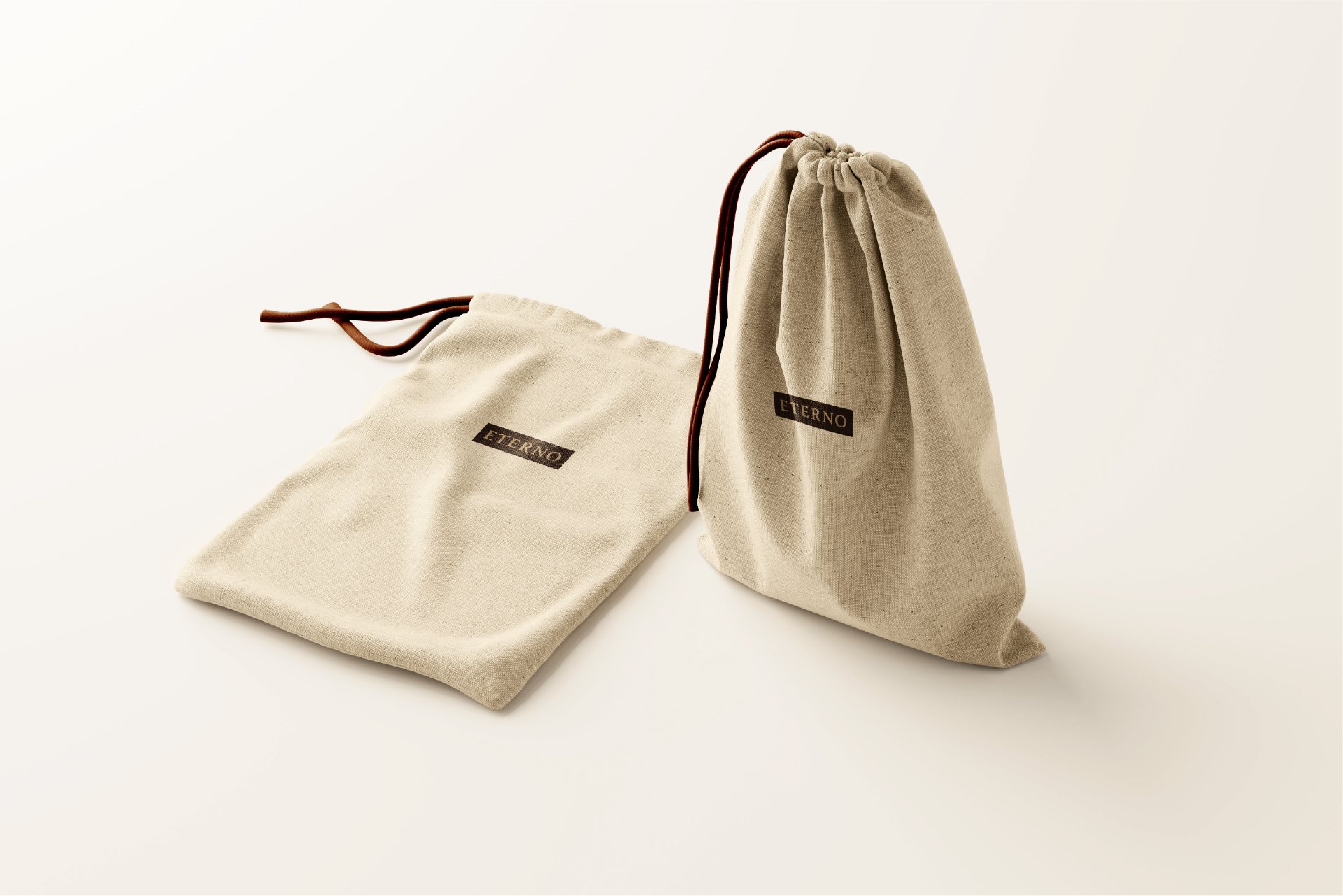 A cream canvas dust bag with a drawstring and a small Eterno label