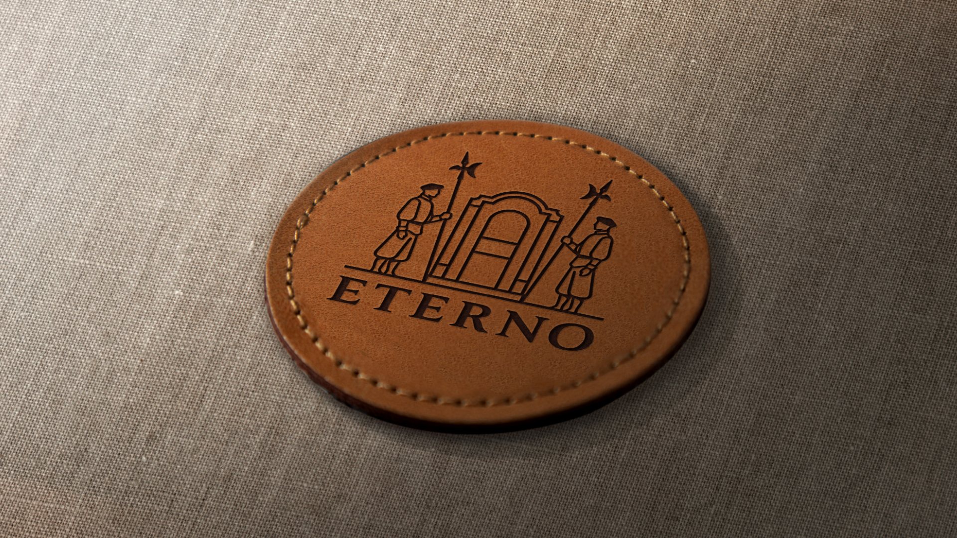 A round stitched leather patch with the crest on linen