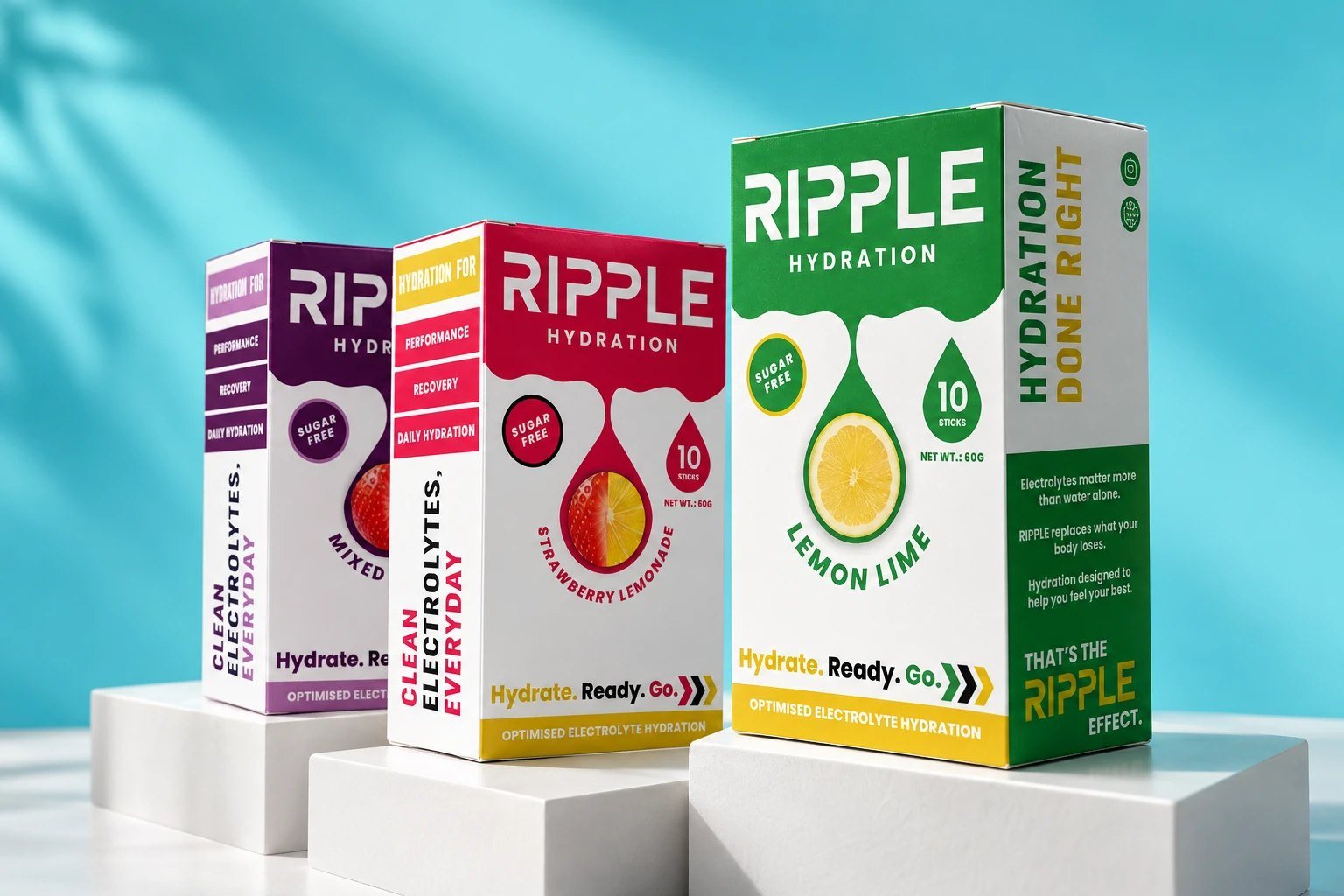Mixed Berry, Strawberry Lemonade and Lemon Lime boxes on white plinths against a sunlit blue wall