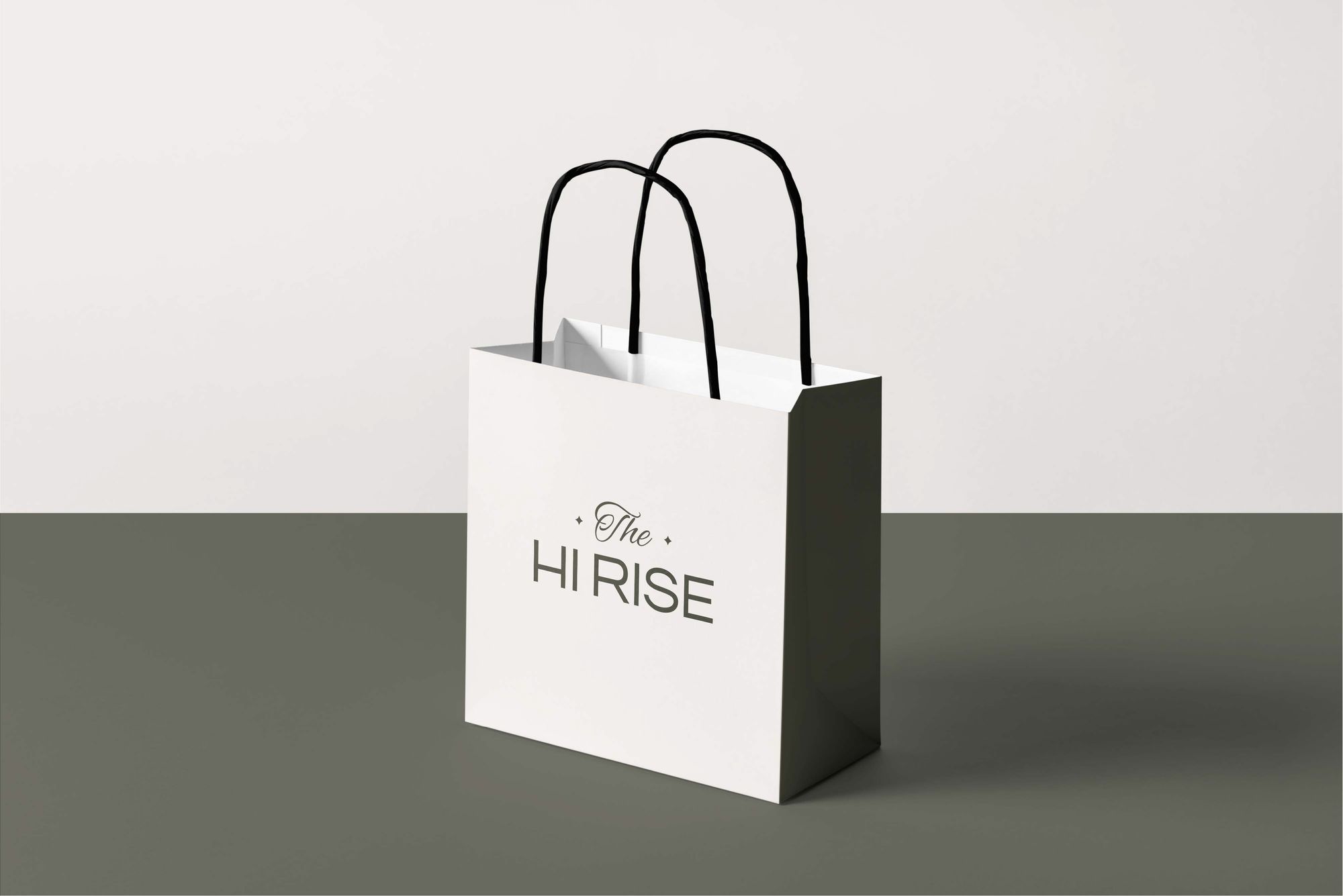 A white paper bag with the logo on an olive floor