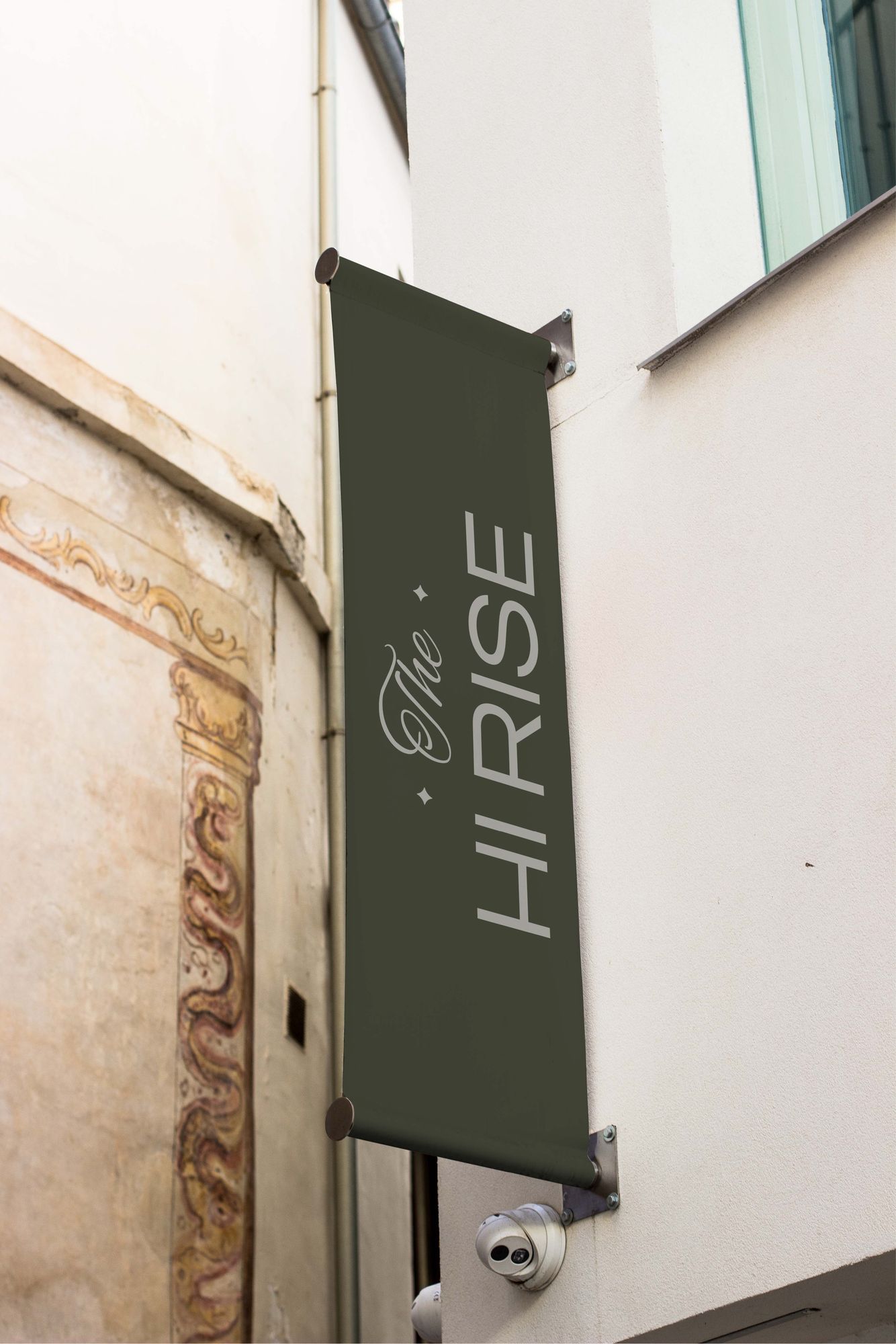 An olive banner with the logo hanging from a white wall