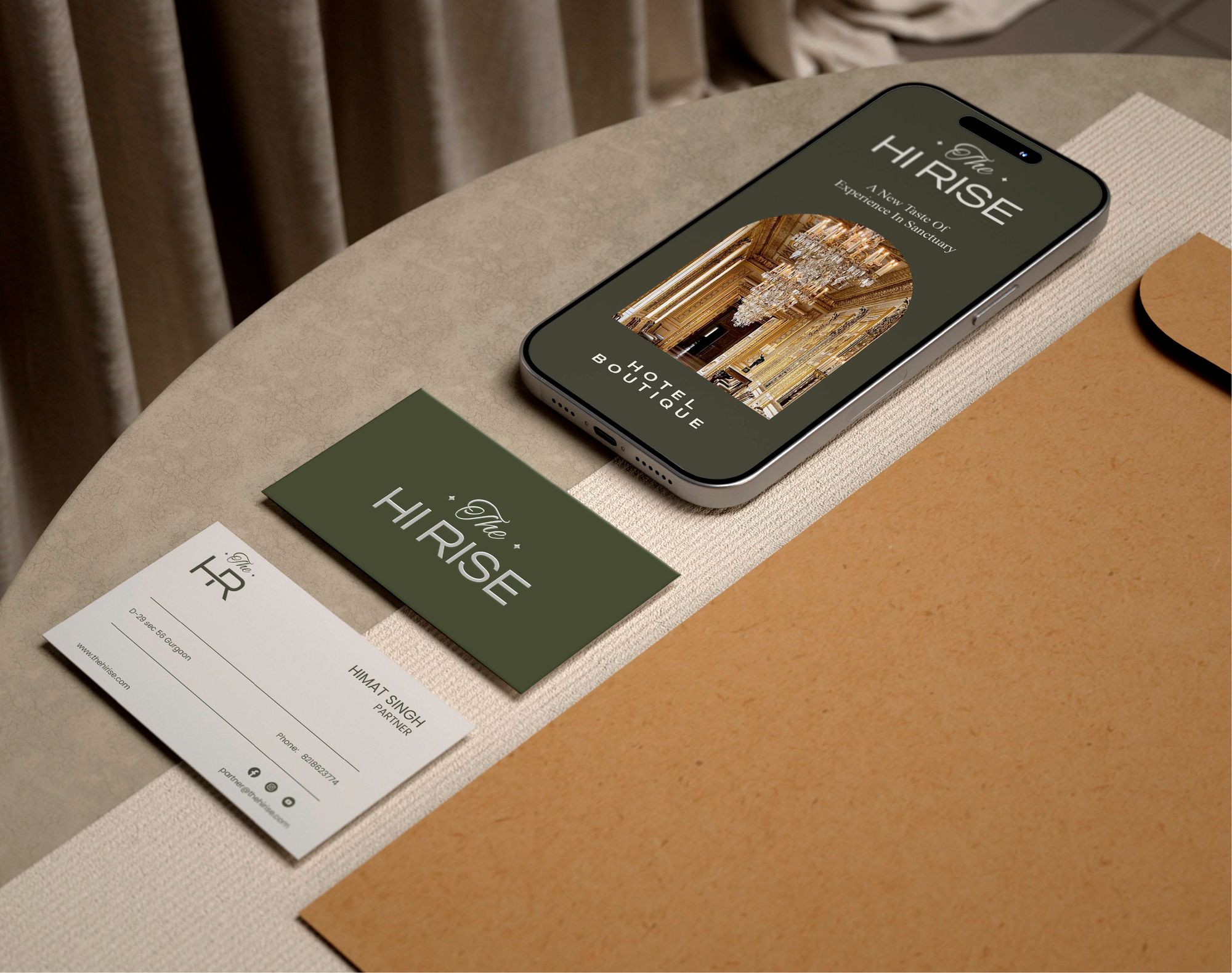 A phone showing the hotel app beside olive and linen business cards