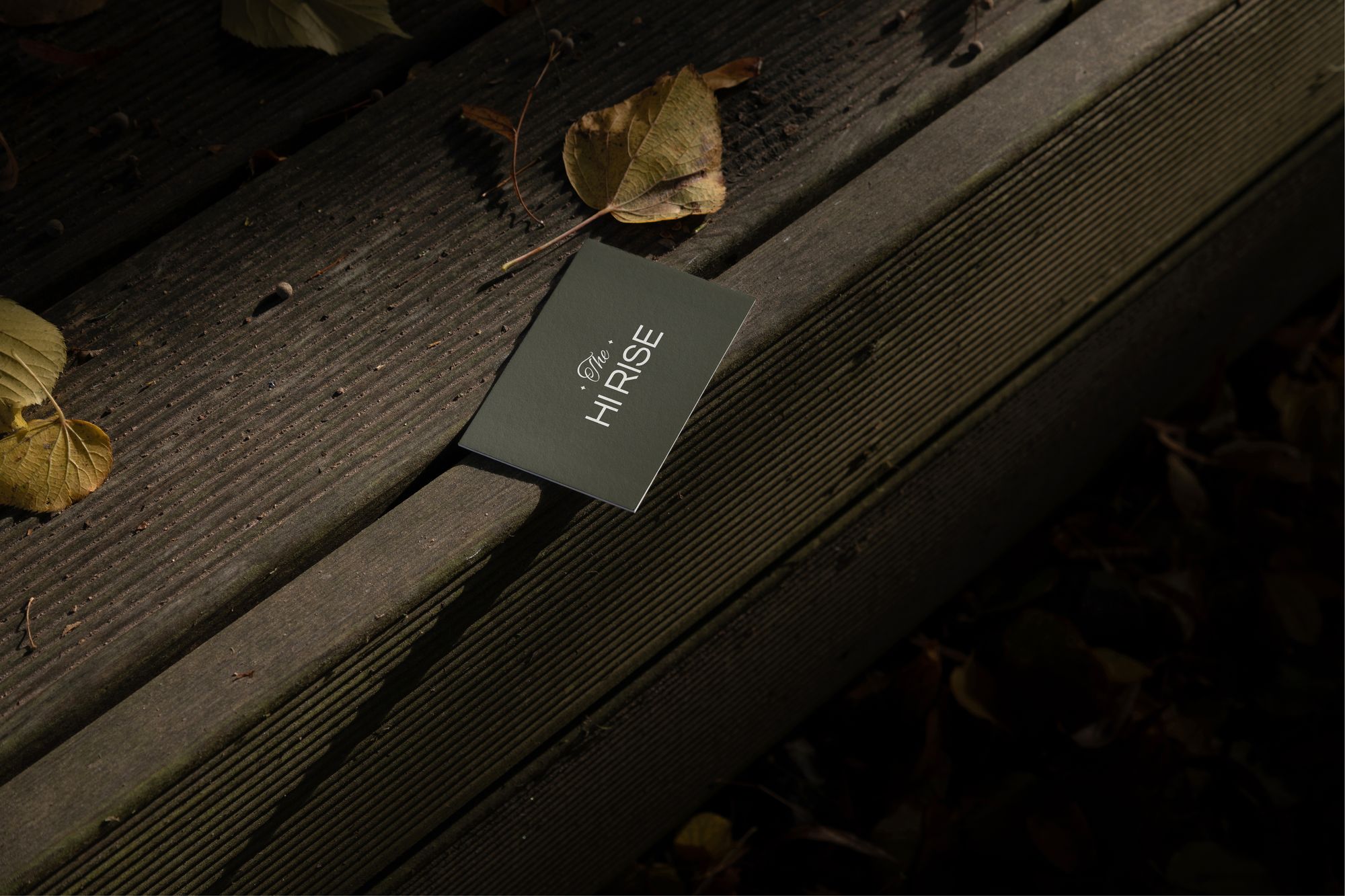 An olive key card resting on dark wooden steps