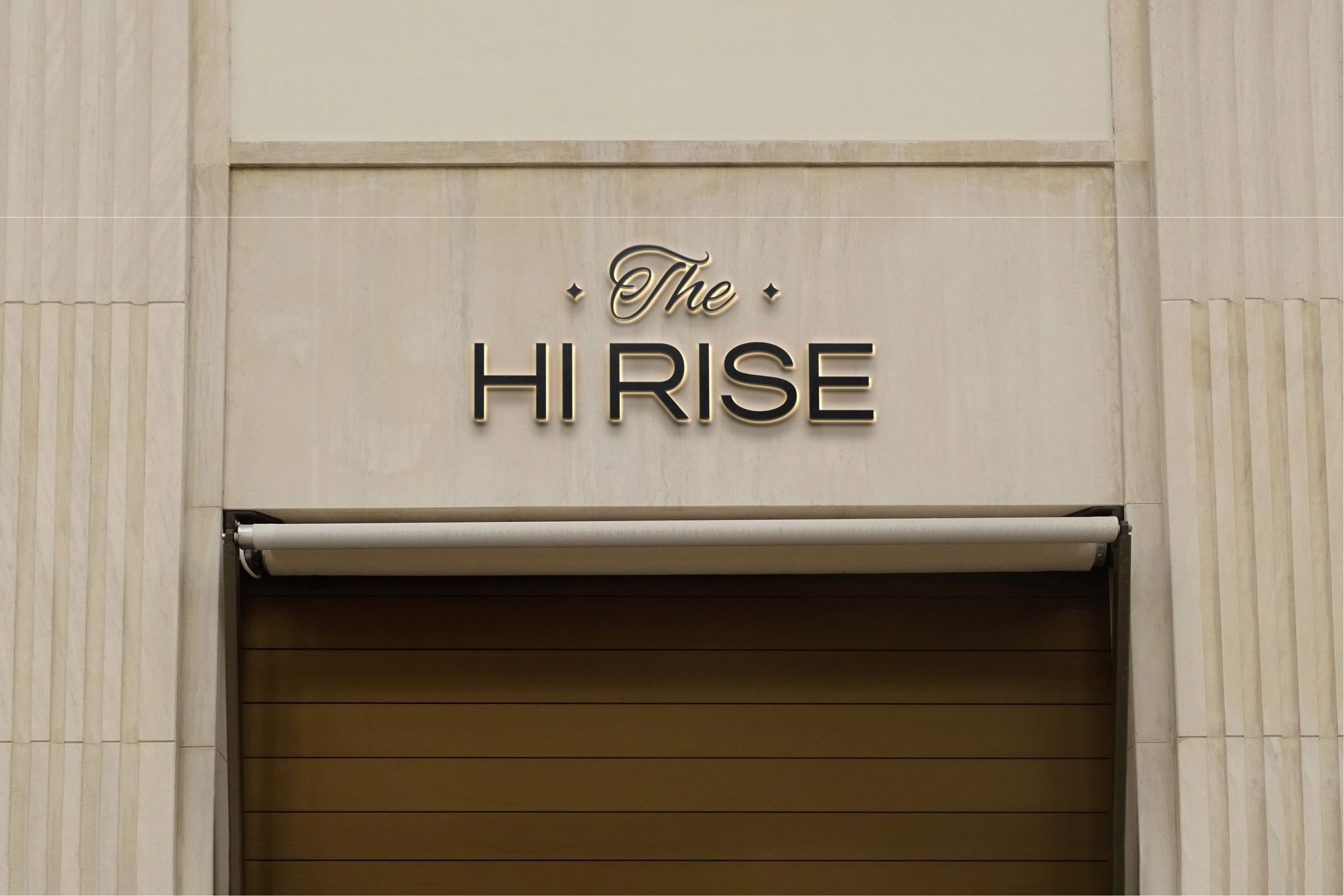The Hi Rise lettering in raised metal on pale stone above a wooden door